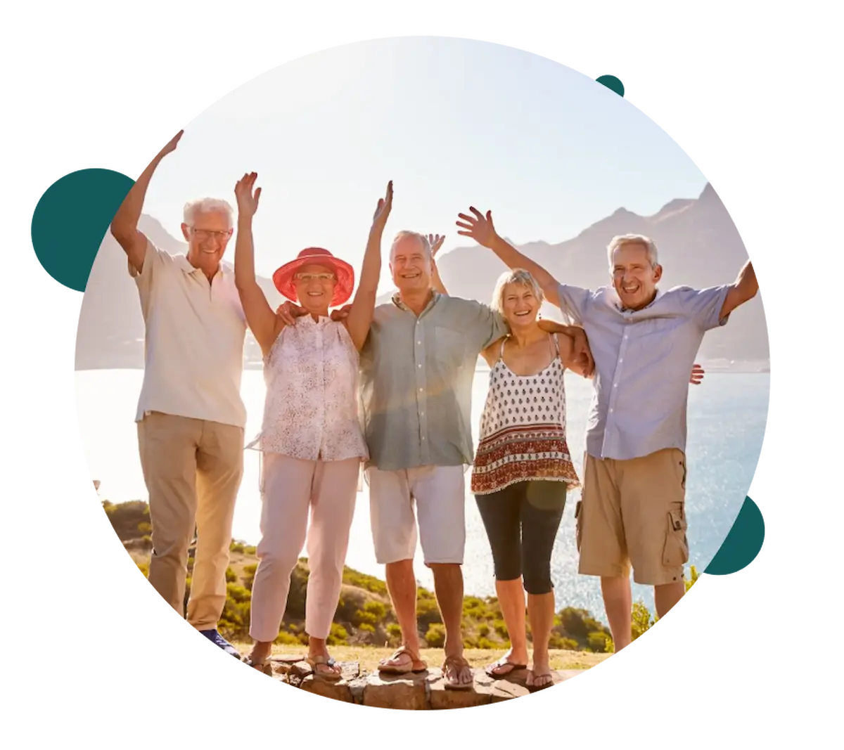 Group of smiling older adults raising arms by the sea
